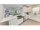 Modern kitchen features quartz counters, stainless appliances, and seamless flow into an adjacent living space at 3027 Formia Ct, Lakewood Ranch, FL 34211