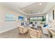 Elegant living room with a tray ceiling, tile floors and a view of the patio and pond at 3027 Formia Ct, Lakewood Ranch, FL 34211