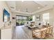 Elegant living room with a tray ceiling, tile floors and a view of the patio and pond at 3027 Formia Ct, Lakewood Ranch, FL 34211