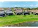 Rear of house with screened in porch overlooking yard and pond in a community setting at 3027 Formia Ct, Lakewood Ranch, FL 34211