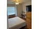Bedroom with wood floors, storage chest, mounted rods, and a large television at 3287 Rackley Rd, Brooksville, FL 34604