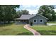 Inviting home with a cozy front porch and a red brick walkway, surrounded by a green lawn at 3287 Rackley Rd, Brooksville, FL 34604