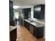 View of the spacious kitchen boasting stainless steel appliances, dark wood cabinets and tile flooring at 3287 Rackley Rd, Brooksville, FL 34604
