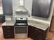 Close up of the stove with stainless steel vent hood, dark wood cabinets and marble countertops at 3287 Rackley Rd, Brooksville, FL 34604