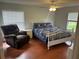 Comfortable main bedroom featuring wood floors, ceiling fan and two bright windows at 3287 Rackley Rd, Brooksville, FL 34604