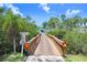 Community wooden bridge crossing waterway amidst lush landscaping and tropical foliage at 3333 26Th E Ave # 1104, Bradenton, FL 34208
