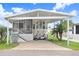 Charming home featuring a covered carport, grill, manicured lawn, and delightful landscaping with palm trees at 3333 26Th E Ave # 1104, Bradenton, FL 34208