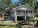Inviting raised bungalow with a porch, American flag, and nestled amid trees on a well-kept lot at 35236 Reynolds St, Dade City, FL 33523