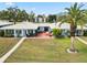 A backyard with an open patio, palm trees, and well-manicured green grass at 3649 Somerville Dr # 1507, Sarasota, FL 34232