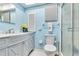 Bright bathroom with a white vanity, blue walls, and a glass enclosed shower at 3649 Somerville Dr # 1507, Sarasota, FL 34232