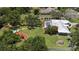 Aerial view showing large manicured lot, metal roof, and screened-in pool at 3764 Oak Grove Dr, Sarasota, FL 34243