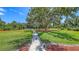 Concrete walkway leading through the spacious green backyard at 3764 Oak Grove Dr, Sarasota, FL 34243