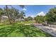 Spacious backyard with lush green lawn, mature trees, cozy seating area, and screened in lanai at 3764 Oak Grove Dr, Sarasota, FL 34243