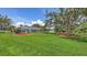 Lush backyard with mature trees, meticulously maintained lawn, and screened in lanai at 3764 Oak Grove Dr, Sarasota, FL 34243