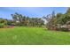 Wide expanse of green backyard with mature trees and manicured landscaping at 3764 Oak Grove Dr, Sarasota, FL 34243
