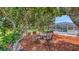 Seating area nestled among shady trees, overlooking pool and screened in lanai at 3764 Oak Grove Dr, Sarasota, FL 34243