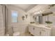 Well-lit bathroom boasts a white vanity, modern fixtures, wainscoting, and a framed mirror at 3764 Oak Grove Dr, Sarasota, FL 34243