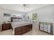 Cozy bedroom with neutral decor, including a wooden bed frame, soft bedding and light-colored flooring at 3764 Oak Grove Dr, Sarasota, FL 34243