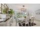 Bright dining area features a large window with a view of the landscaped yard and modern light fixture at 3764 Oak Grove Dr, Sarasota, FL 34243