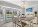 Bright dining area features a bay window overlooking the pool and backyard, a modern chandelier, and neutral decor at 3764 Oak Grove Dr, Sarasota, FL 34243