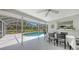 Outdoor dining set on a screened patio, overlooking a sparkling swimming pool and lush greenery at 3764 Oak Grove Dr, Sarasota, FL 34243