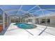 Inviting screened-in pool area with ample deck space, surrounded by lush landscaping and a clear blue sky at 3764 Oak Grove Dr, Sarasota, FL 34243