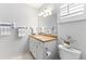 Bright bathroom featuring a vanity with granite countertops, tiled floor, and a decorative light fixture at 3978 Overlook Bend Ter # 25, Sarasota, FL 34232