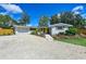 Charming single-story home featuring a yellow door, neutral paint, gravel driveway, and well-maintained landscaping at 4151 Olive Ave, Sarasota, FL 34231