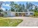 Charming home featuring a well-maintained yard, welcoming gravel driveway, and a bright yellow front door at 4151 Olive Ave, Sarasota, FL 34231