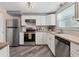 Updated kitchen with stainless steel appliances, white cabinets, and butcher block countertops at 4151 Olive Ave, Sarasota, FL 34231