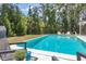 Refreshing backyard pool surrounded by lush landscaping and relaxing seating area at 4151 Olive Ave, Sarasota, FL 34231