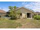 Backyard with lush flowering bushes, screened in porch, and sliding glass doors at 4203 Carriage Dr # 27, Sarasota, FL 34241