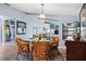 Open-concept dining room with a glass table, woven chairs, and a view into the living area at 4203 Carriage Dr # 27, Sarasota, FL 34241