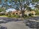 Charming single-story home with a well-manicured lawn and a large, mature tree providing shade at 4203 Carriage Dr # 27, Sarasota, FL 34241