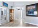 Inviting foyer with light wood-look flooring, a mirror, and decorative art pieces at 4203 Carriage Dr # 27, Sarasota, FL 34241