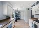 The kitchen area features wood-look floors, shelving for storage, and white cabinets at 4203 Carriage Dr # 27, Sarasota, FL 34241