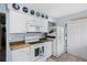 The kitchen features white cabinets and appliances and is in close proximity to the kitchen door at 4203 Carriage Dr # 27, Sarasota, FL 34241