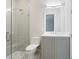 Modern bathroom featuring a walk-in shower with glass door, gray vanity, and mosaic tile flooring at 430 Pheasant Way, Sarasota, FL 34236