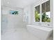 Bright bathroom with glass shower, modern tub, and marble tiling at 430 Pheasant Way, Sarasota, FL 34236