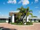 Exterior of the clubhouse featuring circular drive, lush landscaping, and ample parking at 430 Pheasant Way, Sarasota, FL 34236