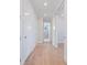 Hallway features light wood floors, white trim, doors, and a partial view of an ensuite bathroom at 430 Pheasant Way, Sarasota, FL 34236