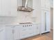 Close-up of a gourmet kitchen featuring white cabinetry, quartz countertops, and stainless steel appliances at 430 Pheasant Way, Sarasota, FL 34236