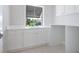 Well-lit laundry room featuring white cabinets and countertops, a sink, and hexagon tile flooring at 430 Pheasant Way, Sarasota, FL 34236