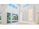 Bright living room with access to the lanai featuring a swimming pool and a stone accent wall with custom lighting at 430 Pheasant Way, Sarasota, FL 34236