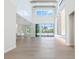 Inviting living room with a towering ceiling, wood beam accents, stylish tile wall with shelving, and sliding glass doors at 430 Pheasant Way, Sarasota, FL 34236