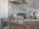Outdoor kitchen featuring a stainless steel grill, granite countertops, and wood cabinets at 430 Pheasant Way, Sarasota, FL 34236