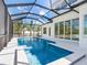 Beautiful pool inside of a screen, surrounded by a tile deck and palm trees at 430 Pheasant Way, Sarasota, FL 34236