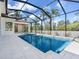 Inviting screened-in pool with a spillover spa and lush tropical foliage in the background at 430 Pheasant Way, Sarasota, FL 34236
