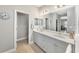 Bathroom featuring double sinks, white cabinets, and a large mirror at 4406 Rustling Pines Ter, Parrish, FL 34219