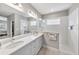 Modern bathroom with double sinks, quartz counters, walk-in shower, and white tile at 4406 Rustling Pines Ter, Parrish, FL 34219